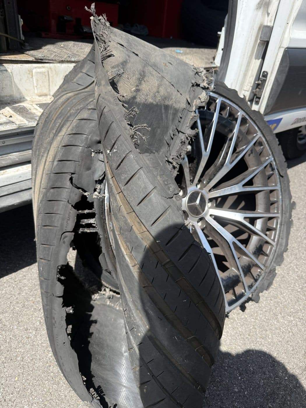 A shredded tyre still on its alloy wheel after a blowout