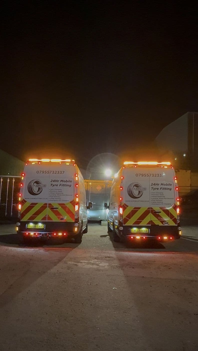 The two JL Mobile Tyres vans parked side by side at night with their beacons on