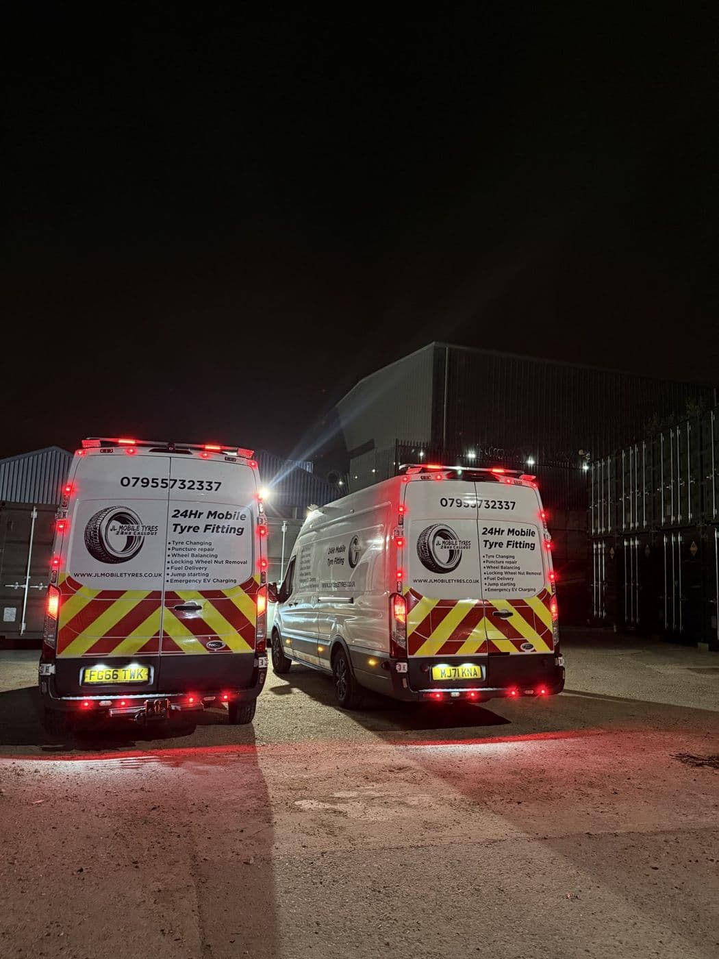 Both JL Mobile Tyres vans at night with amber beacons and red and yellow chevrons